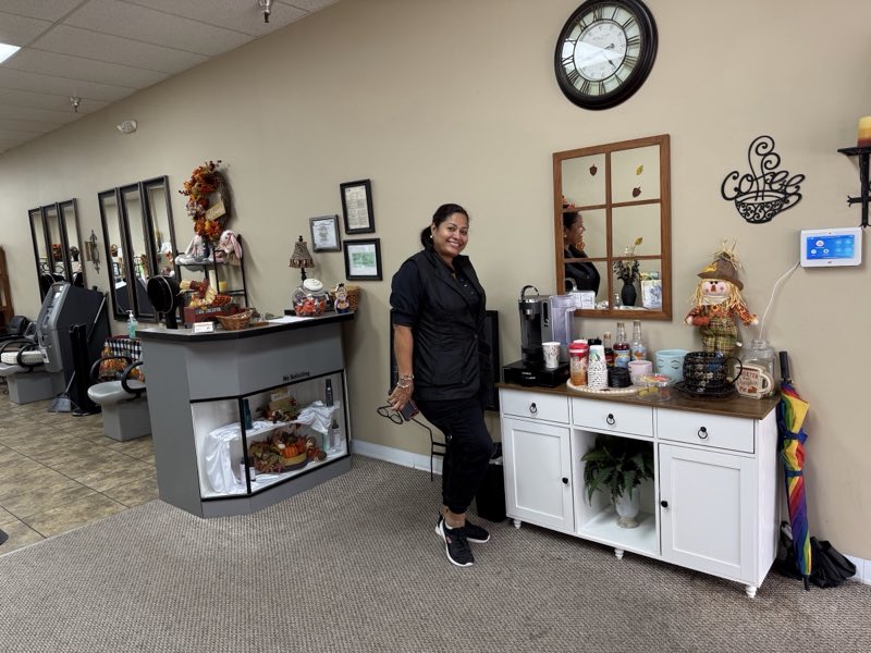 A smiling team member by the welcoming reception and coffee corner
