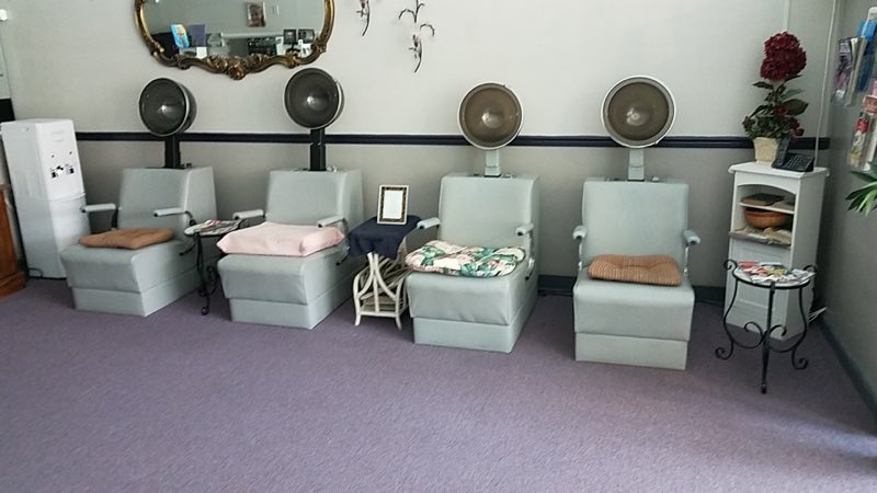 A row of classic hood-dryer stations along the salon wall